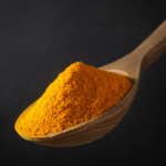 Firefly_A -spoon shot-—a wooden spoon lifting a heap of bright turmeric powder, showing the f 480298