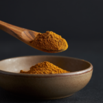 Firefly_A -spoon shot-—a wooden spoon lifting from a bowl of bright Cumin Powder, showing the 480298