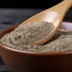 Firefly_A -spoon shot-—a wooden spoon lifting from a bowl of bright black pepper Powder, show 393750