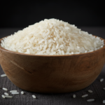 Firefly_Gemini Flash_A wooden bowl full of bright white indian non - basmati rice, the fine grain against 393750