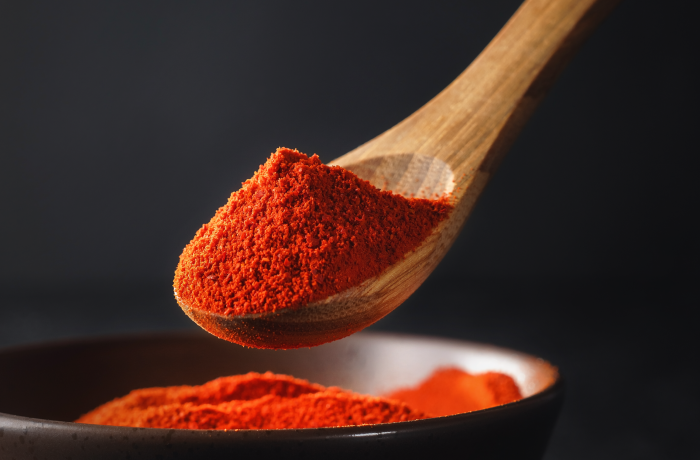 Firefly_A -spoon shot-—a wooden spoon lifting from a bowl of bright red chilli Powder, showin 480298