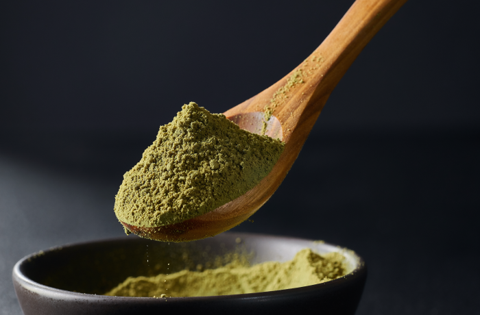 Firefly_A -spoon shot-—a wooden spoon lifting from a bowl of green Coriander Powder, showing 480298